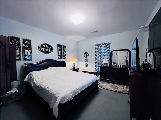 bedroom featuring visible vents and wood finished floors