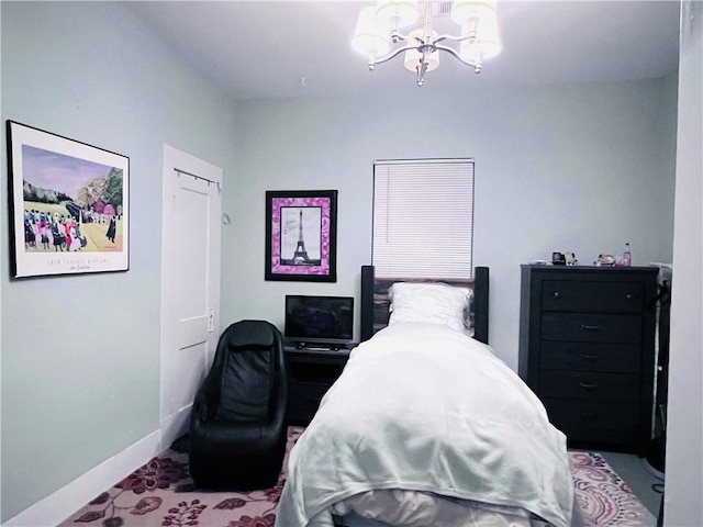 bedroom with a notable chandelier and baseboards