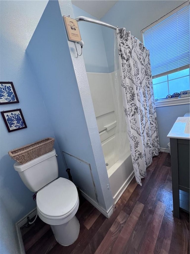 bathroom featuring vanity, toilet, wood finished floors, and shower / bath combo with shower curtain