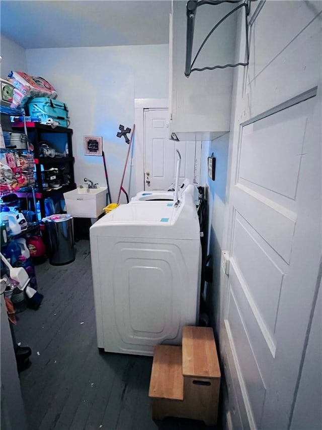 clothes washing area featuring a sink, washer / dryer, dark wood-style flooring, and laundry area