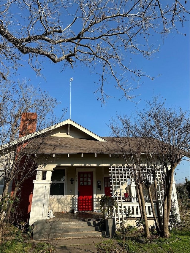 view of front of home with covered porch and a chimney