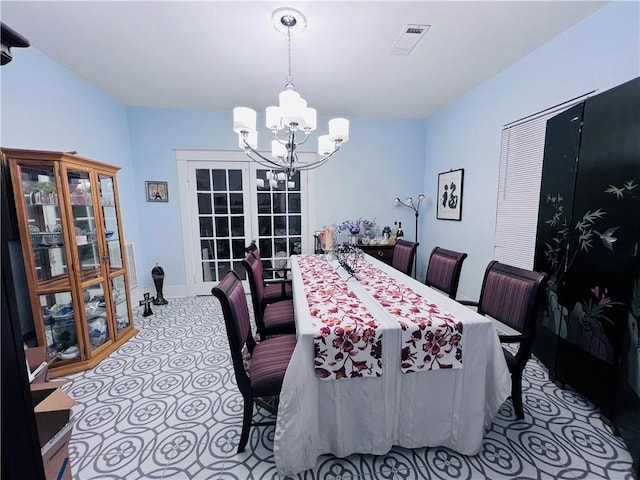 dining space featuring a chandelier, visible vents, and french doors