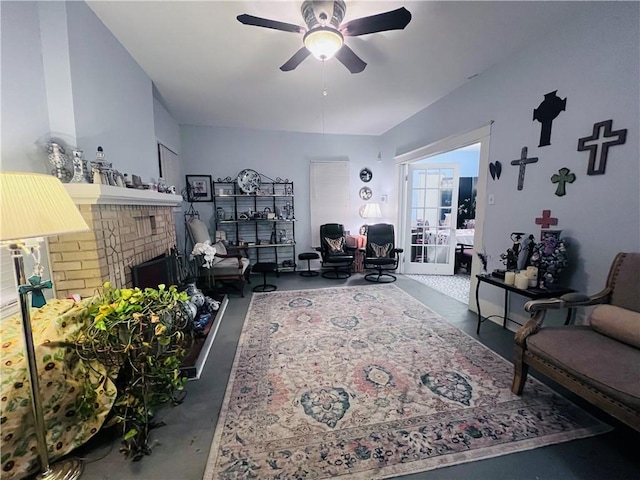 living room featuring a fireplace, concrete floors, and a ceiling fan