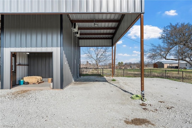 view of outdoor structure featuring a carport and fence
