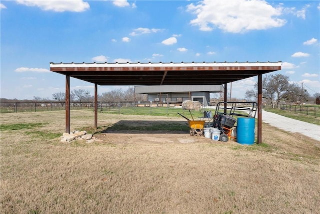 view of yard featuring an exterior structure, driveway, a carport, and an outbuilding