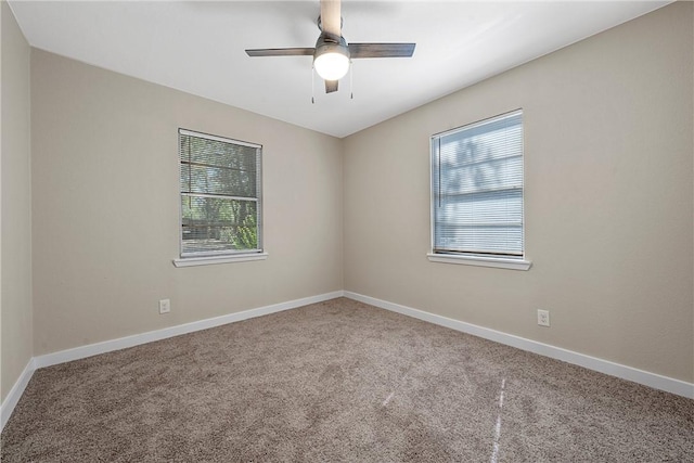 carpeted empty room featuring baseboards and ceiling fan