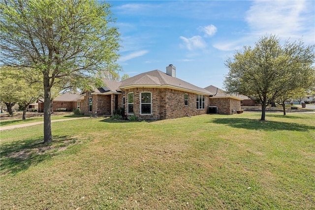 301 Whispering Meadows Dr, Hewitt, TX 76643 - view of property exterior with brick siding, a yard, central AC unit, and a chimney