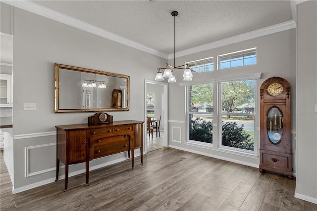 301 Whispering Meadows Dr, Hewitt, TX 76643 - dining space with wood finished floors, ornamental molding, a textured ceiling, and a chandelier