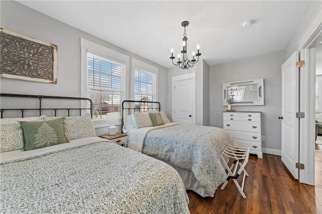 bedroom with dark wood finished floors, baseboards, and a chandelier