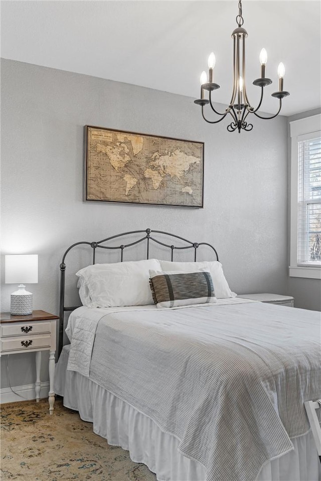 bedroom with baseboards and a chandelier