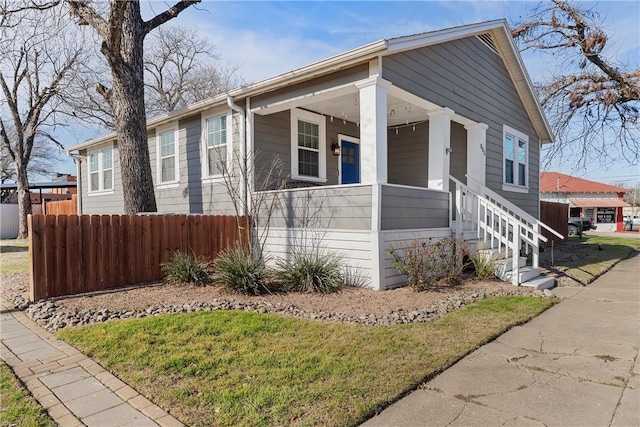 view of front of home featuring a porch and fence