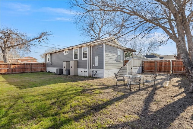 back of house featuring central air condition unit, a lawn, and a fenced backyard