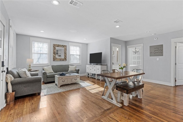 living area with visible vents, baseboards, and wood finished floors