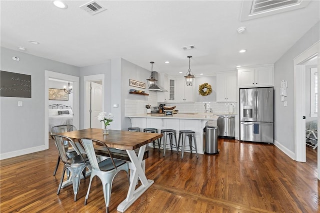 dining space with visible vents, baseboards, and dark wood-style floors