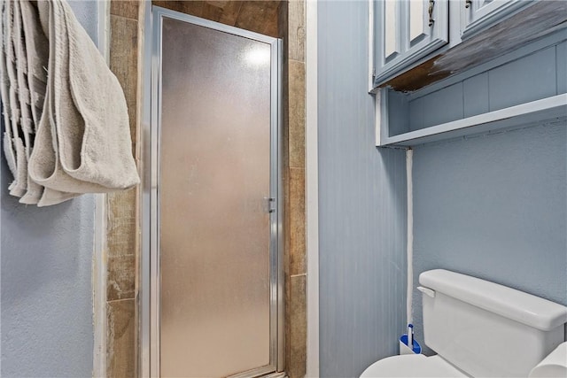 full bath featuring a shower stall and toilet