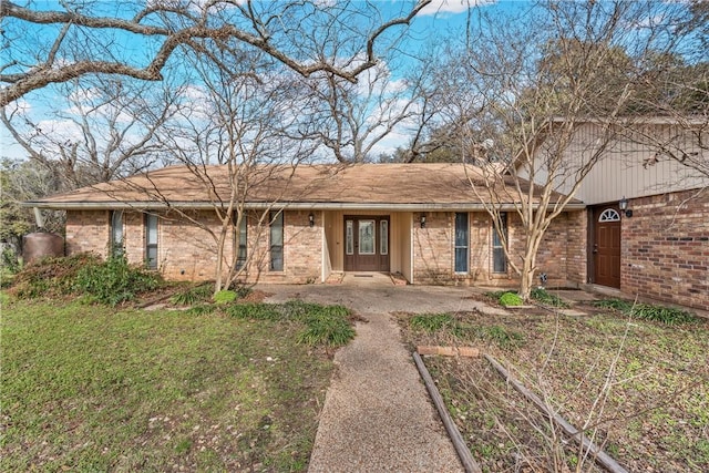 single story home featuring brick siding and a front lawn