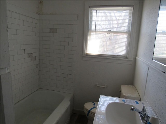 2800 Speight Ave, Waco, TX 76711 - bathroom featuring toilet, shower / bathing tub combination, a textured wall, and a sink