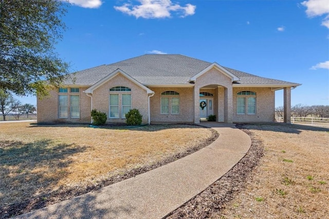 single story home with brick siding, a front lawn, and fence