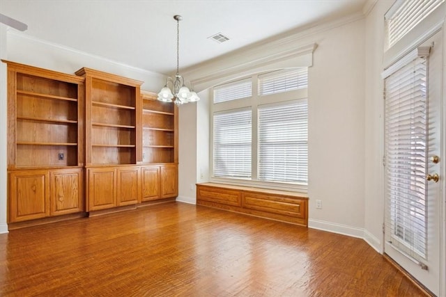 interior space with visible vents, a chandelier, dark wood-style flooring, and ornamental molding
