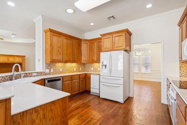 kitchen with tasteful backsplash, visible vents, ornamental molding, white appliances, and a sink