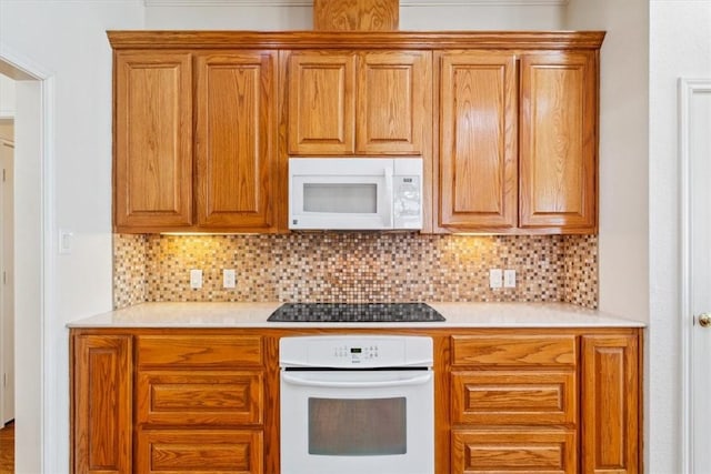kitchen featuring white appliances, light countertops, and backsplash