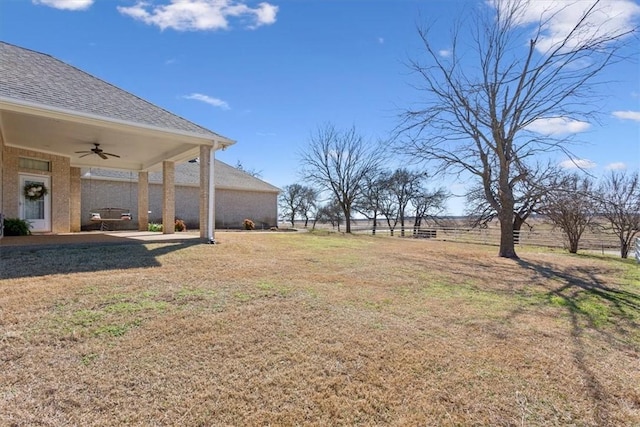 view of yard with fence and ceiling fan
