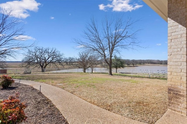 view of yard featuring fence and a water view