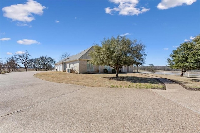 exterior space featuring a lawn, an attached garage, and concrete driveway