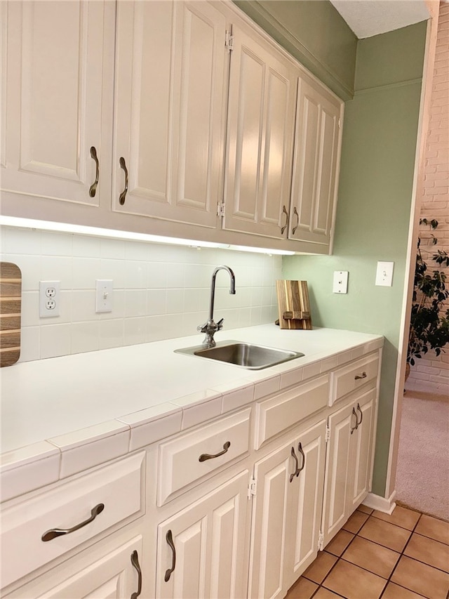 1016 Cardinal Dr, Woodway, TX 76712 - kitchen with a sink, tasteful backsplash, light tile patterned flooring, and white cabinets