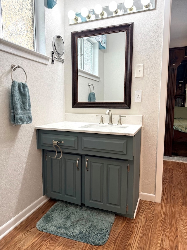 1016 Cardinal Dr, Woodway, TX 76712 - bathroom featuring vanity, baseboards, wood finished floors, and a textured wall