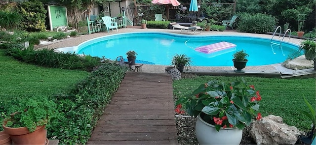 pool featuring a lawn and a patio