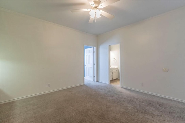 empty room with baseboards, light colored carpet, ceiling fan, and ornamental molding