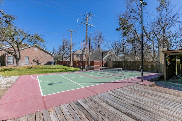 view of basketball court with a yard, a tennis court, community basketball court, and fence