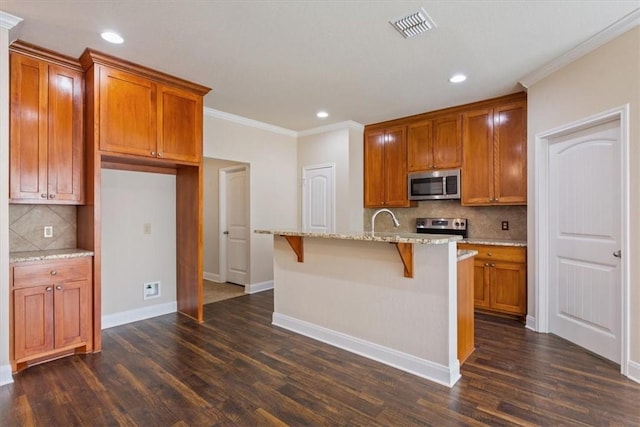 107 Indian Trails Rd, Riesel, TX 76682 - kitchen featuring light stone counters, visible vents, appliances with stainless steel finishes, and dark wood-style flooring