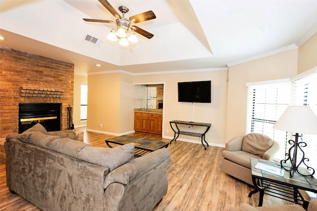 4020 River Oaks Cir, Temple, TX 76504 - living area with light wood finished floors, a ceiling fan, baseboards, crown molding, and a fireplace