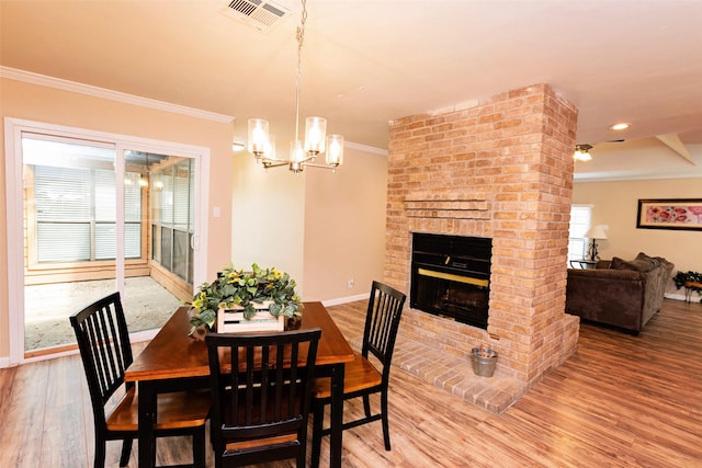 4020 River Oaks Cir, Temple, TX 76504 - dining space with crown molding, wood finished floors, baseboards, a chandelier, and a fireplace