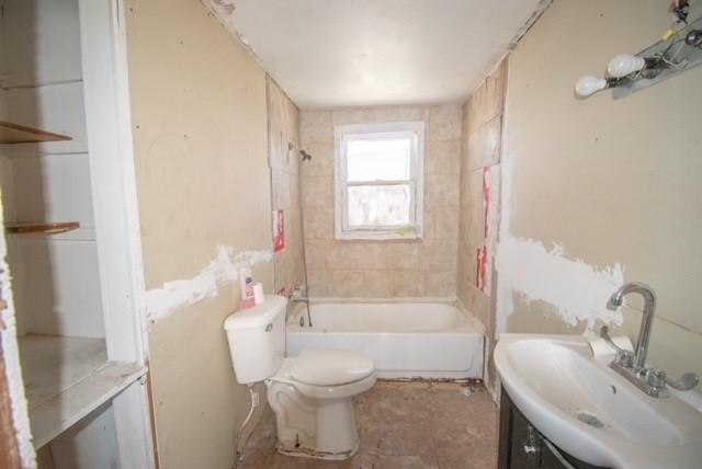 full bath featuring toilet, vanity, and bathing tub / shower combination