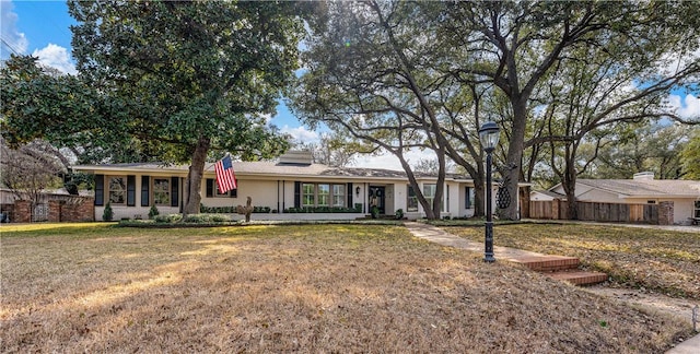 single story home featuring a front yard and fence