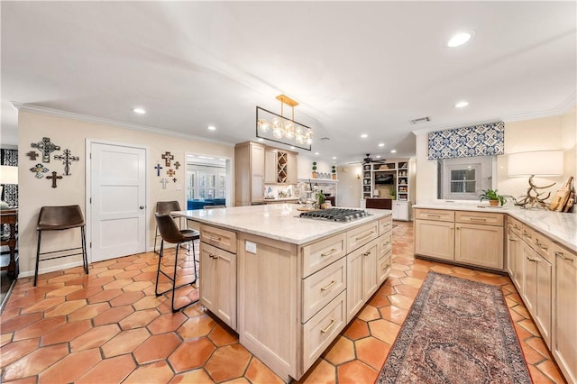 kitchen featuring crown molding, light stone counters, recessed lighting, and a center island