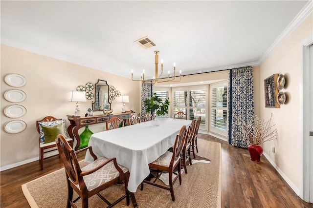 dining room with visible vents, crown molding, baseboards, a chandelier, and wood finished floors