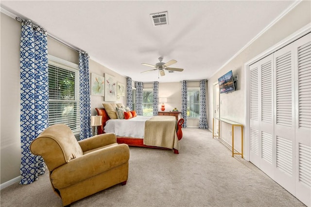 carpeted bedroom featuring visible vents, multiple windows, ceiling fan, and ornamental molding