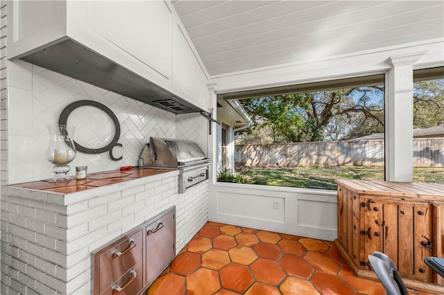 view of patio featuring area for grilling, an outdoor kitchen, and fence