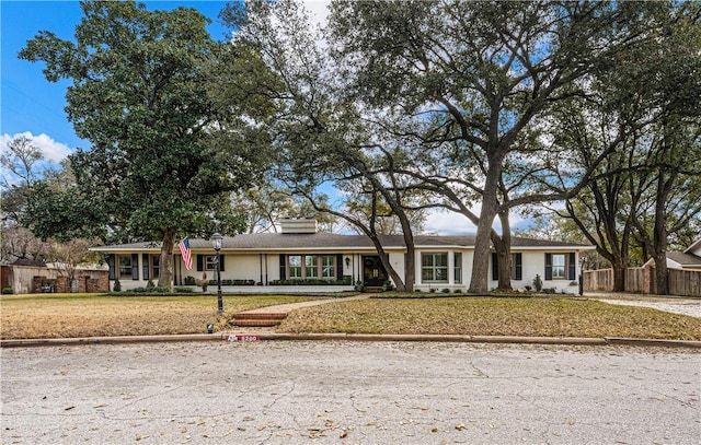 single story home with a front lawn and fence