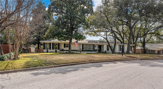 ranch-style house with a front lawn and fence