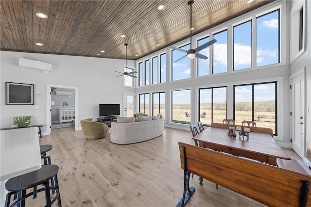 living area with recessed lighting, a ceiling fan, a wall unit AC, and a healthy amount of sunlight