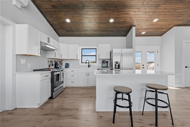 kitchen featuring appliances with stainless steel finishes, under cabinet range hood, vaulted ceiling, and wood ceiling