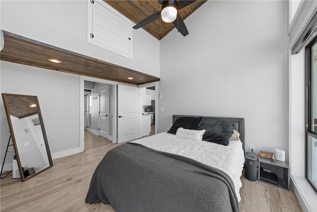 bedroom with high vaulted ceiling, light wood-type flooring, multiple windows, and wooden ceiling