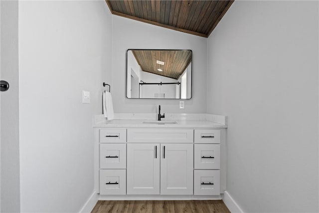 bathroom with baseboards, wooden ceiling, wood finished floors, and vaulted ceiling