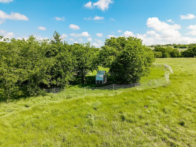 view of yard with fence and a rural view