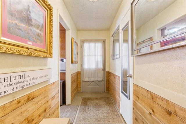 411 Brookwood Dr, Woodway, TX 76712 - doorway featuring a wainscoted wall, wood walls, and a textured ceiling